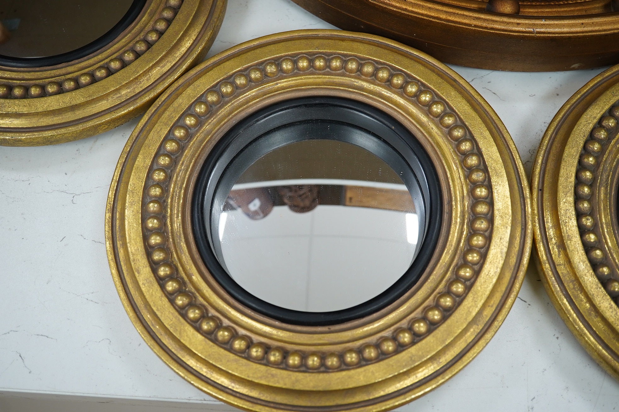 A convex gilt painted wall mirror and four small similar mirrors, convex mirror 46cm diameter (5). Condition - convex mirror, gilt scratched in places, others good